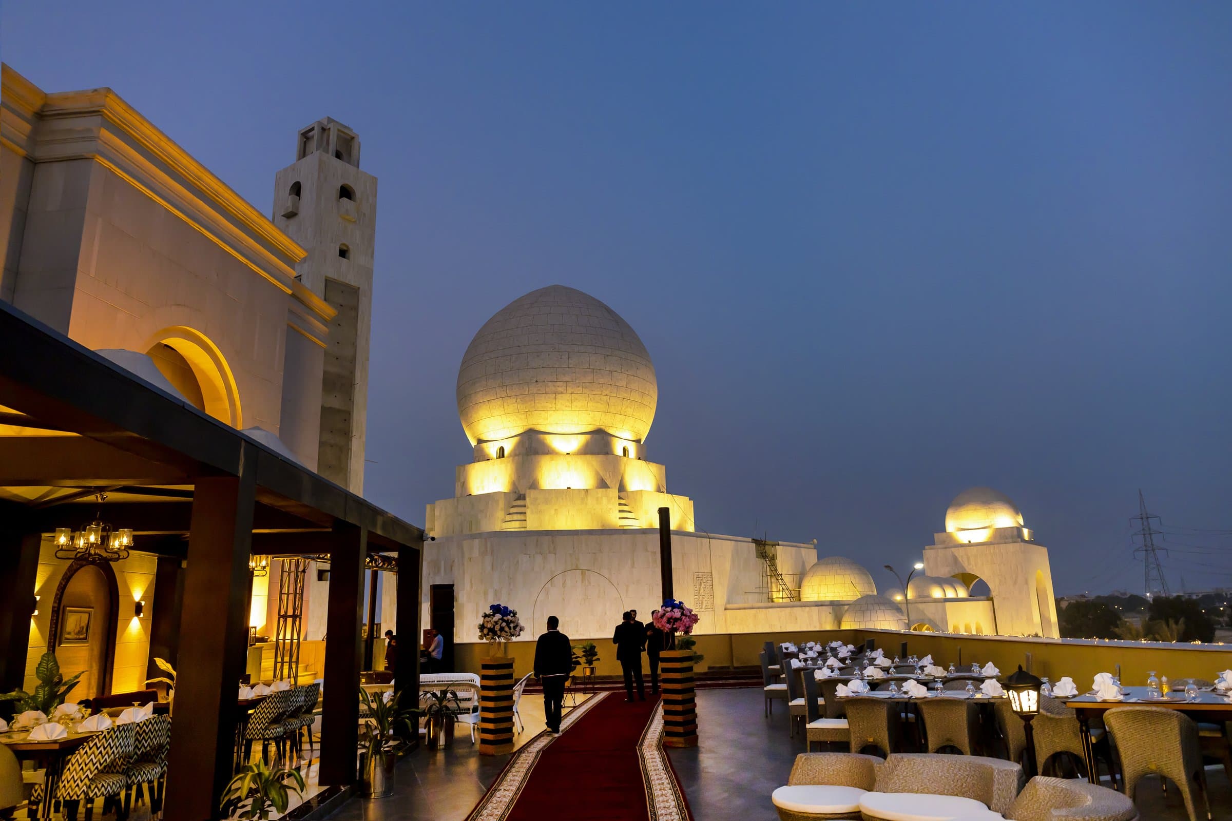 Poet Rooftop Garden at dusk with illuminated white domes and an open-air dining terrace